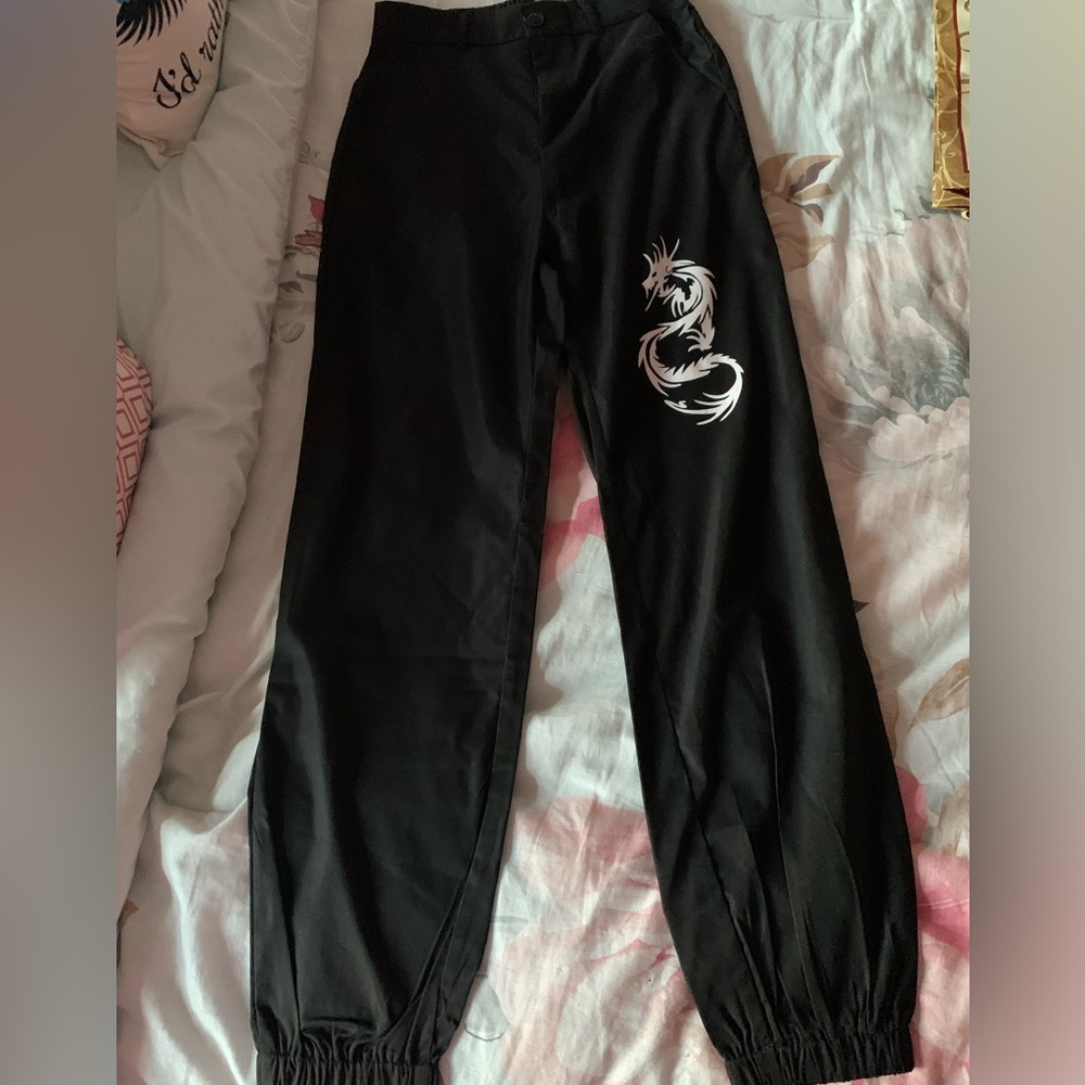 Black pants with white dragon print on right leg